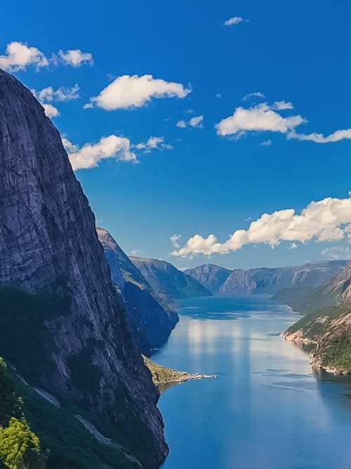 Norwegian fjord, showcasing towering cliffs, lush greenery, and the crystal-clear waters of the fjord. Kjerag, Lysebotn, Lysefjorden, Norway in summer