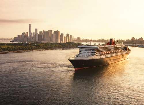 Queen Mary 2 sails out of New York city at sunrise