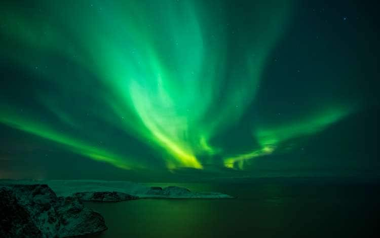 Intense northern lights, Aurora Borealis over Knivskjelloden Island, view from Nordkapp, North Cape, the most northern point of Europe, Finnmark, Norway