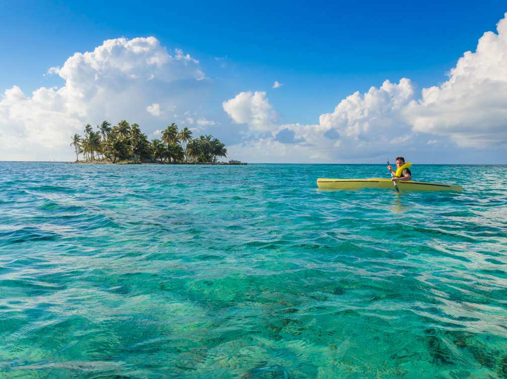 Kayaking in tropical paradise - Canoe floating on transparent turquoise water, Caribbean sea, Belize