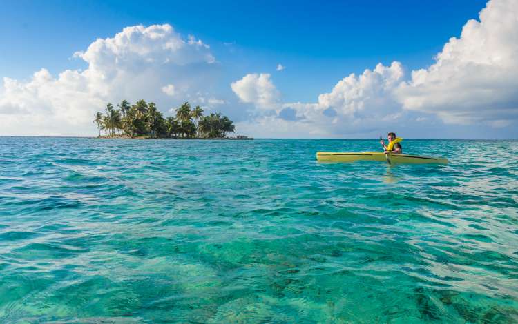 Kayaking in tropical paradise - Canoe floating on transparent turquoise water, Caribbean sea, Belize