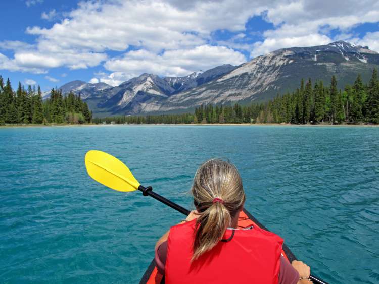 Woman kayaking with red inflatable kayak on turquoise colored Edith Lake, Jasper, Rocky Mountains, Canada; Shutterstock ID 781441195; Invoice Number: -