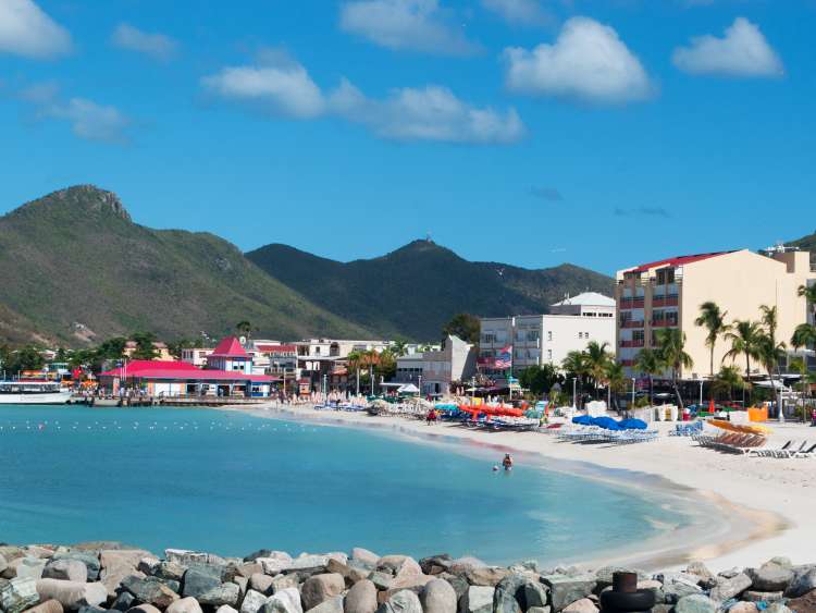 Colourful houses on a white sand beach with palm trees in Philipsburg, St Maarten, Caribbean