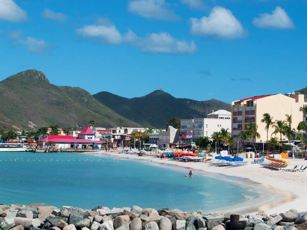 Colourful houses on a white sand beach with palm trees in Philipsburg, St Maarten, Caribbean