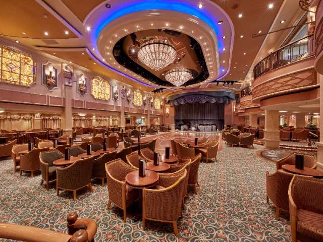 Queen Elizabeth's Queens Room, showing lower deck dancefloor with seating and stage, and mezzanine with shops above