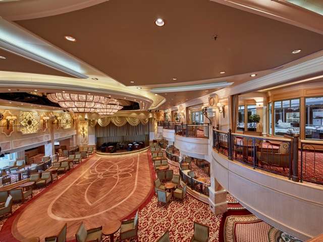 Queen Victoria's Queens Room, showing lower deck dancefloor with seating and stage, and mezzanine with shops above