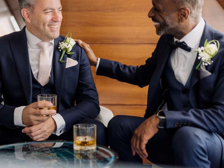 Groom and best man enjoy a glass of whiskey