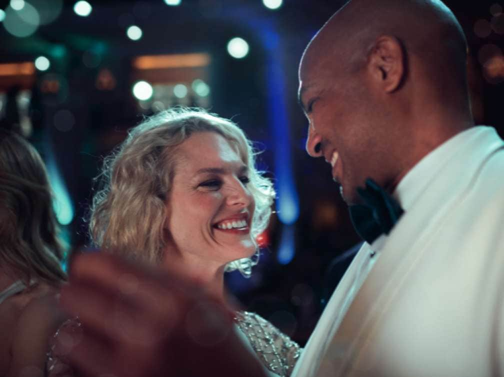 A man in a white tuxedo dancing with a woman during an Ice White Ball gala evening on board a Cunard cruise ship