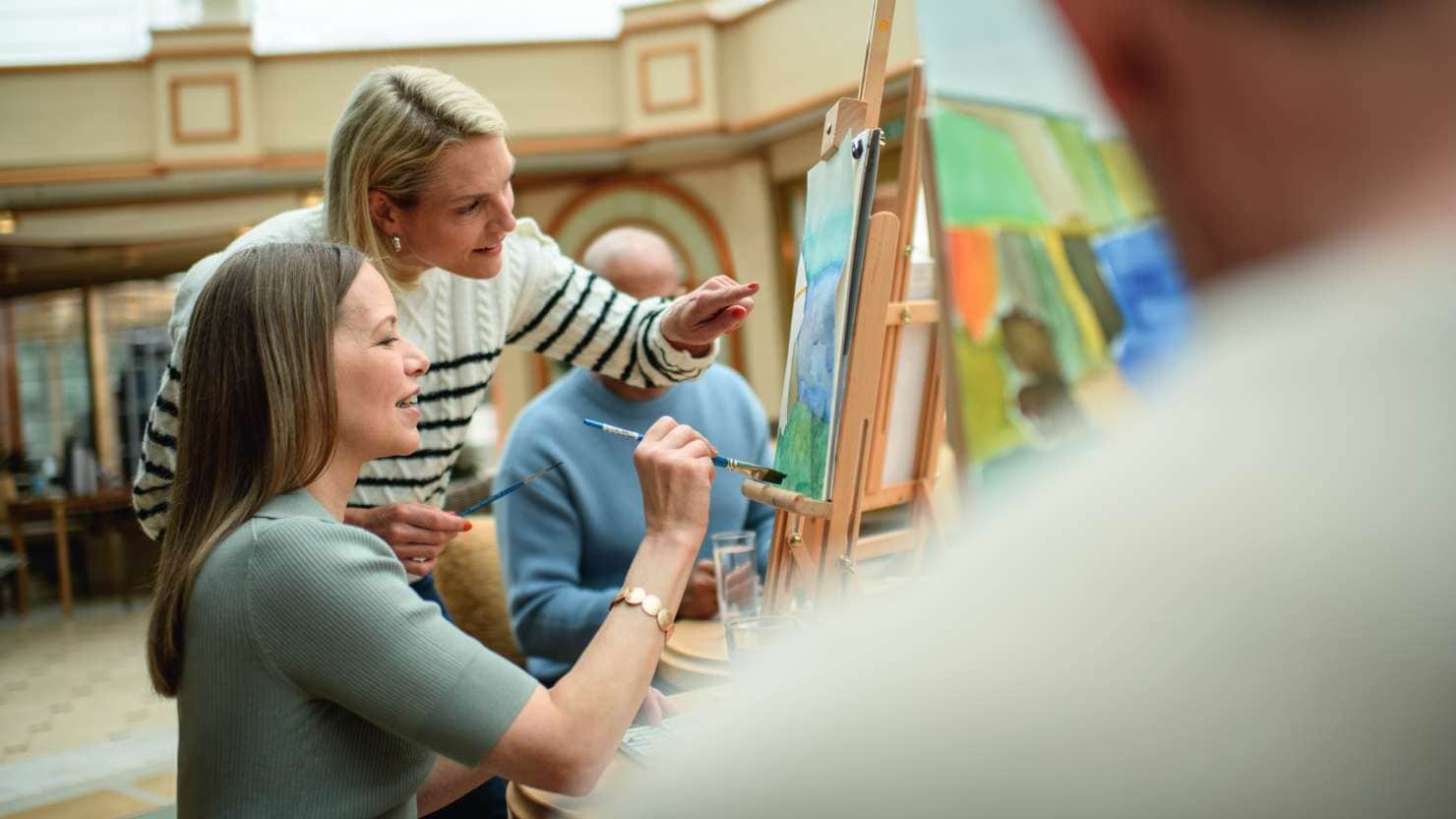 Lady painting in a watercolour class on board