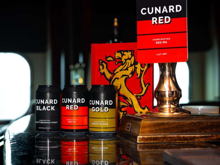 Cans of Cunard Black, Cunard Red and Cunard Gold beers on the bar of the Golden Lion pub, alongside a menu and Cunard Red pump.