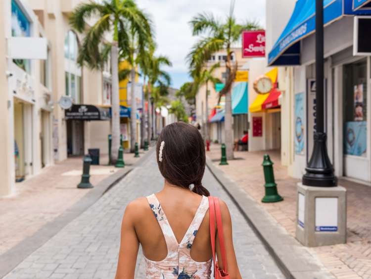 Woman tourist walking in shopping streets of Philipsburg, St Maarten, popular port of call for cruise ship travel destination. Caribbean tropical getaway.; Shutterstock ID 557664088; purchase_order: -; job: -; client: -; other: -