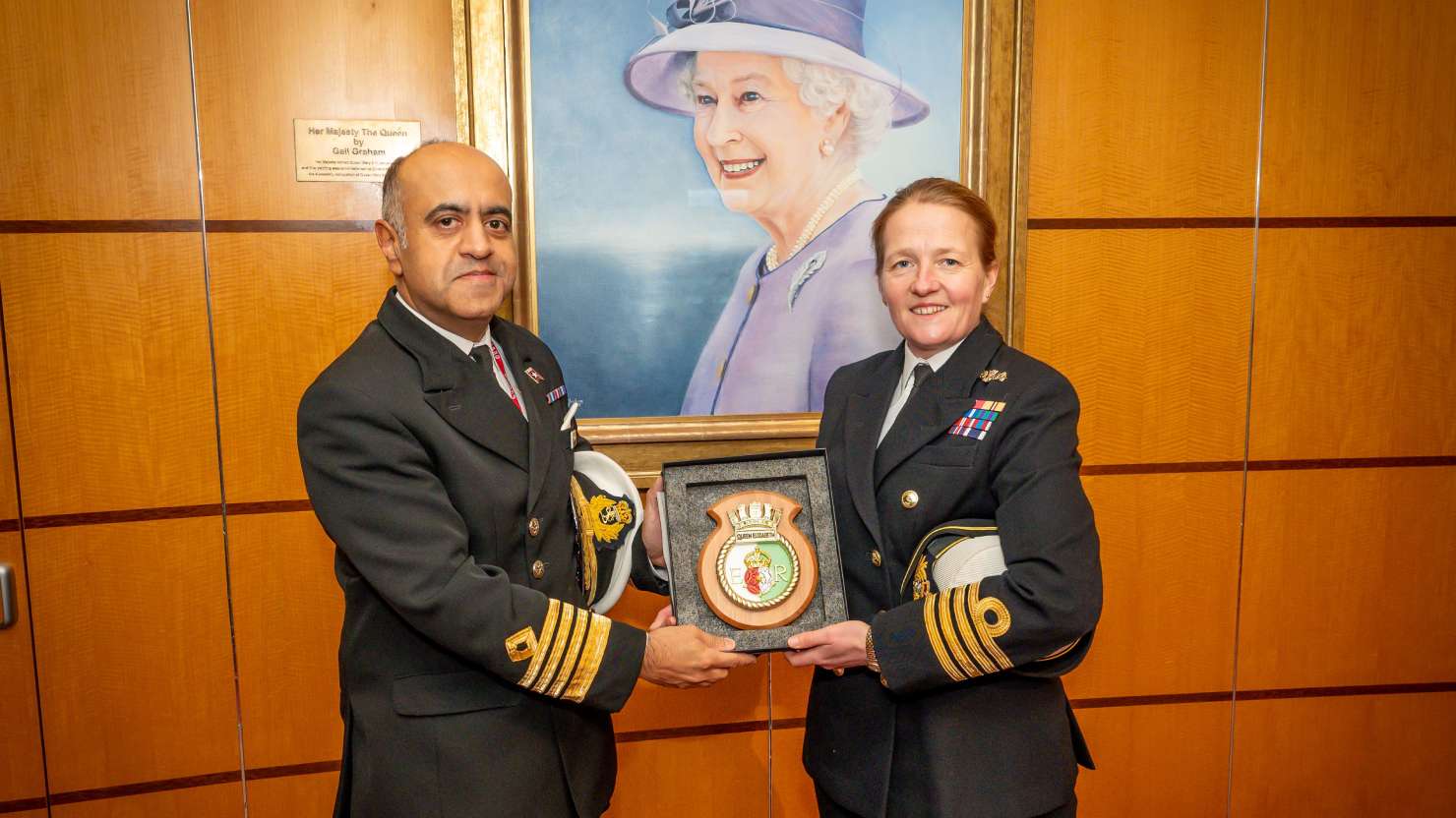 Captain Aseem Hashimi and Captain Claire Thompson exchanging ceremonial plaques