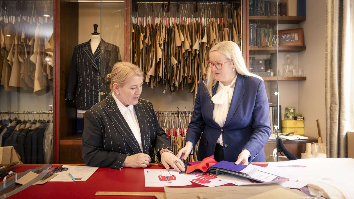 Master tailor Kathryn Sargent and Captain Inger Thorhauge look over uniform designs at the cutting table