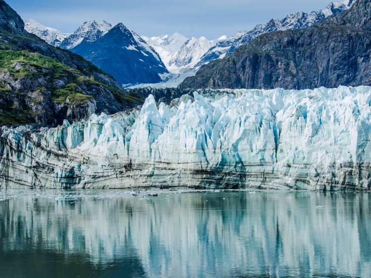 Margerie Glacier in Glacier Bay National Park and Preserve in Southeast Alaska which is twenty-one miles long and one mile wide with layers of rock debris mixed with ice