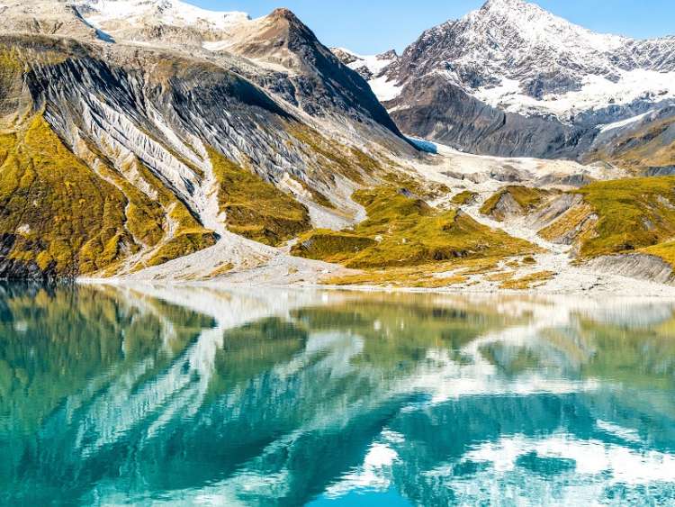 Glacier Bay National Park, Alaska, USA. Amazing glacial landscape showing mountain peaks and glaciers on clear blue sky summer day. Mirror reflection of mountains in still glacial waters.; Shutterstock ID 556661092; purchase_order: n/a; job: Glacier Bay - climate; client: cunard_digital; other: As per agreed allowance