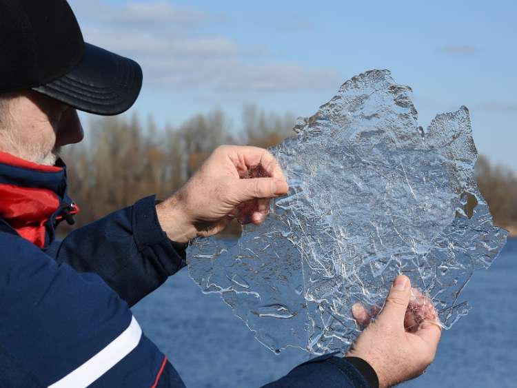 A man scientist holds a sample of translucent ice floe and explores it. Global warming, melting ice, climate change and Environmental protection concept. Ice research. measuring ice runoff; Shutterstock ID 2124625001; purchase_order: n/a; job: Glacier Bay - climate; client: cunard_digital; other: As per agreed allowance