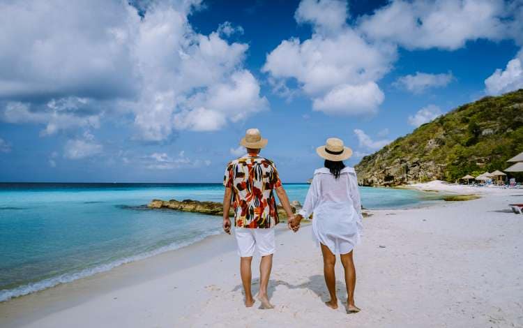  Cas Abou Beach Curacao on the caribbean island of Curacao, Playa Cas Abou in Curacao Caribbean tropical white beach with blue ocean men and woman on the beach, couple mid age on vacation; Shutterstock ID 1976178758; purchase_order: n/a; job: Caribbean Guide; client: cunard_digital; other: 