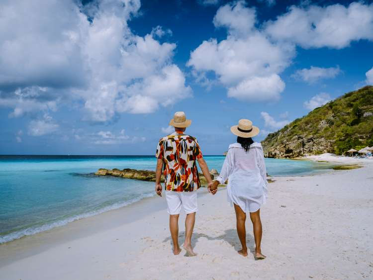  Cas Abou Beach Curacao on the caribbean island of Curacao, Playa Cas Abou in Curacao Caribbean tropical white beach with blue ocean men and woman on the beach, couple mid age on vacation; Shutterstock ID 1976178758; purchase_order: n/a; job: Caribbean Guide; client: cunard_digital; other: 