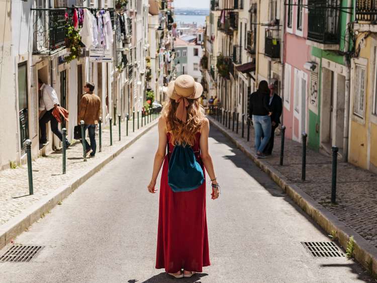 Blonde woman on trip walking by the beautiful southern streets in summer with people in background; Shutterstock ID 737418172; Purchase Order: -