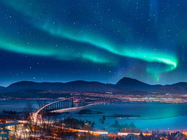 Aurora borealis or Northern lights in the sky over Tromso with Sandnessundet Bridge - Tromso, Norway