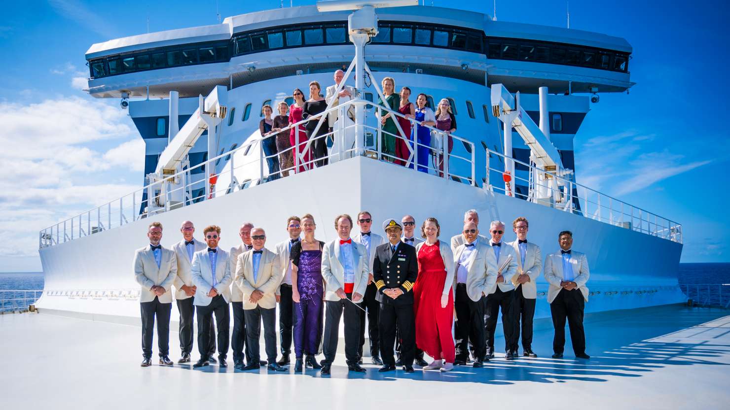 Anthony Inglis and the National Symphony Orchestra smile with Captain Hashmi at the front of Queen Mary 2