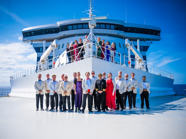 Anthony Inglis and the National Symphony Orchestra smile with Captain Hashmi at the front of Queen Mary 2