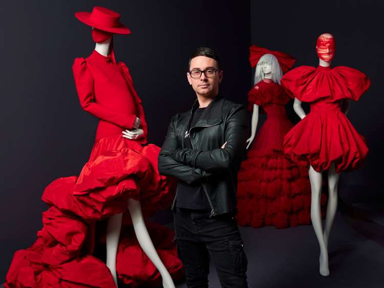 Fashion designer Christian Siriano with mannequins wearing outfits to promote his SCAD Exhibition 