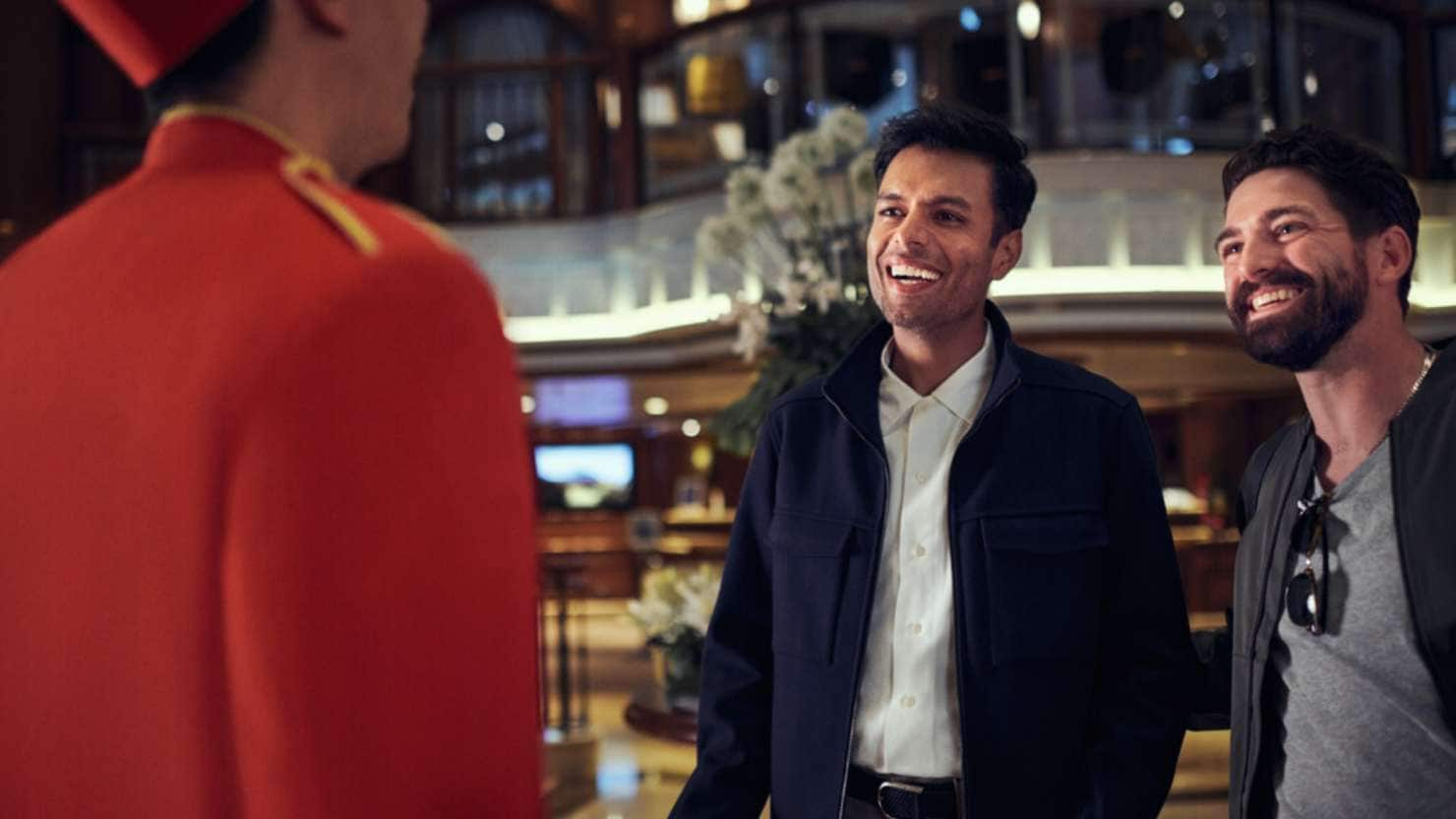 Guests talking to a bellhop on board Queen Elizabeth