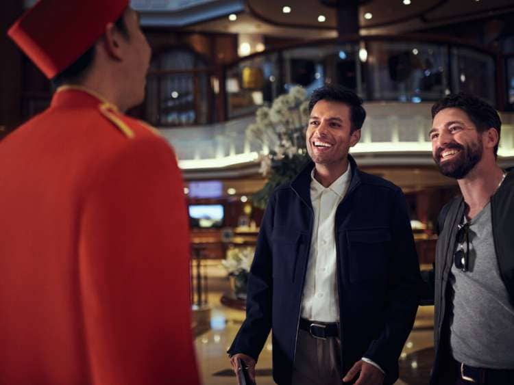 Guests talking to a bellhop on board Queen Elizabeth