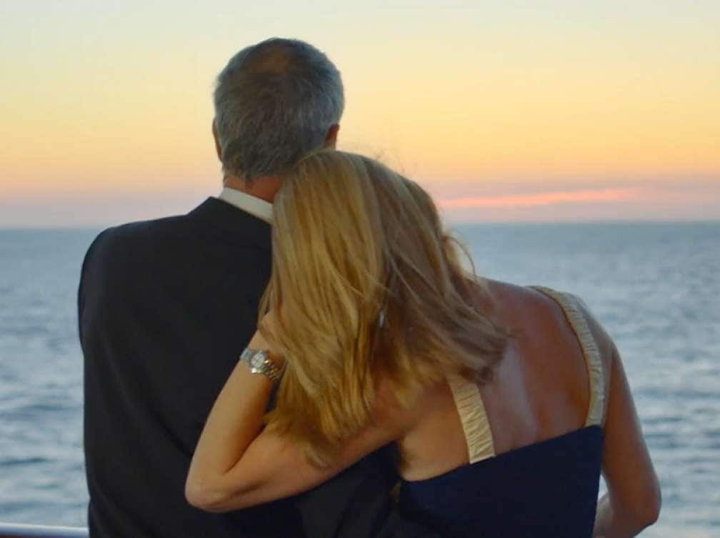 Man and woman admire the sunset on the deck of a Cunard cruise ship