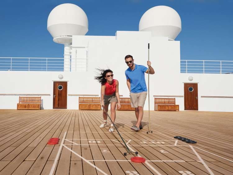 Couple play shuffleboard on Queen Mary 2's deck Asset bank brand shoot 2017