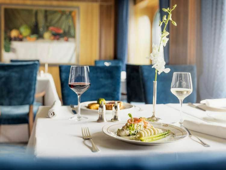 Food at a table in the Britannia Club Restaurant on board Queen Mary 2