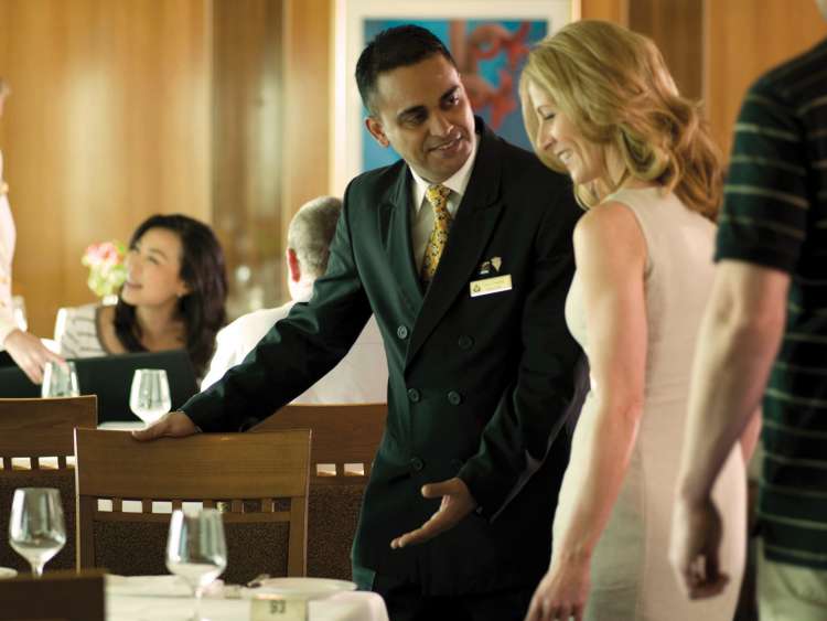 Brand shot of waiter showing guest to table