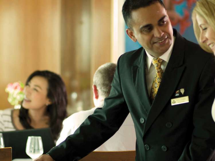 Brand shot of waiter showing guest to table