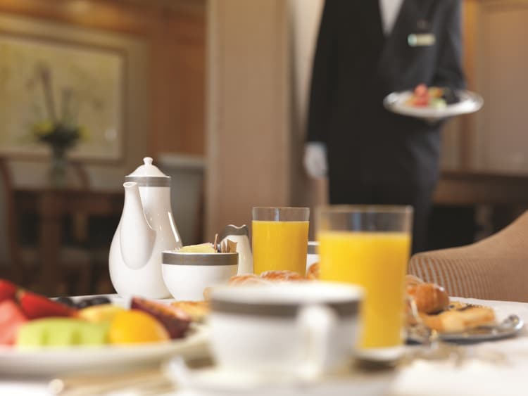 Butler serving room service in a Grills Suite on Queen Victoria