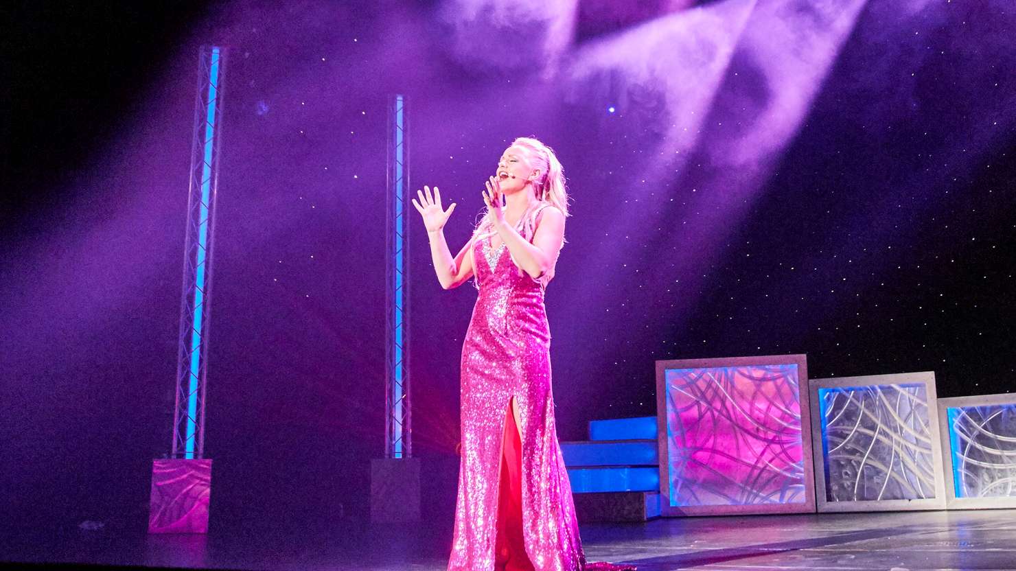 Singer performing on stage in the Royal Court Theatre on Queen Victoria