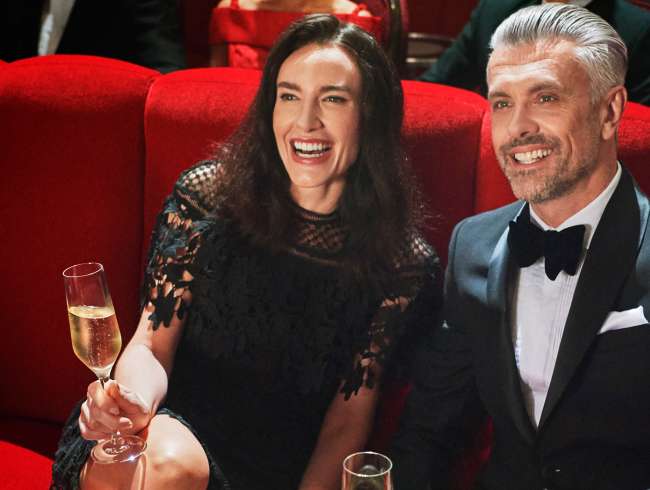 Couple in the Royal Court Theatre, enjoying the show with champagne and chocolates