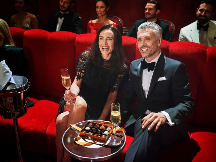 Couple in the Royal Court Theatre, enjoying the show with champagne and chocolates