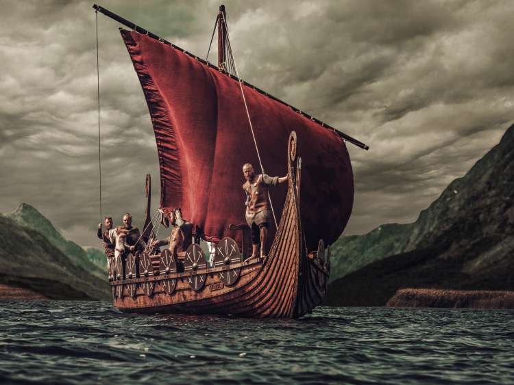 Group of vikings are floating on the sea on Drakkar with mountains on the background.; Shutterstock ID 515156236; purchase_order: N/A; job: ; client: ; other: 