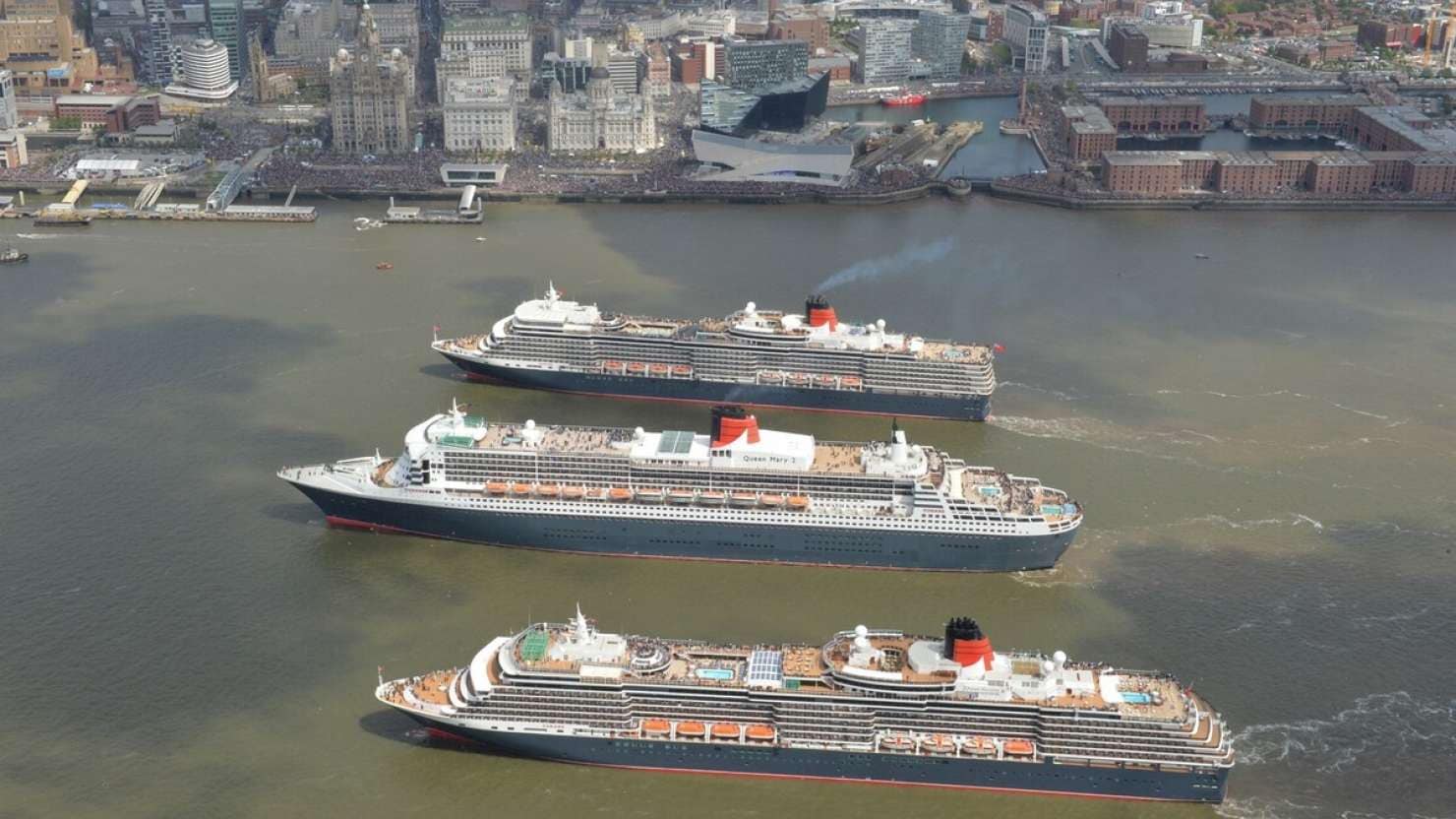 Queen Mary 2, Queen Victoria and Queen Elizabeth meet in the Mersey, Liverpool for a gathering in front of the Three Graces and thousands of people on the riverside.