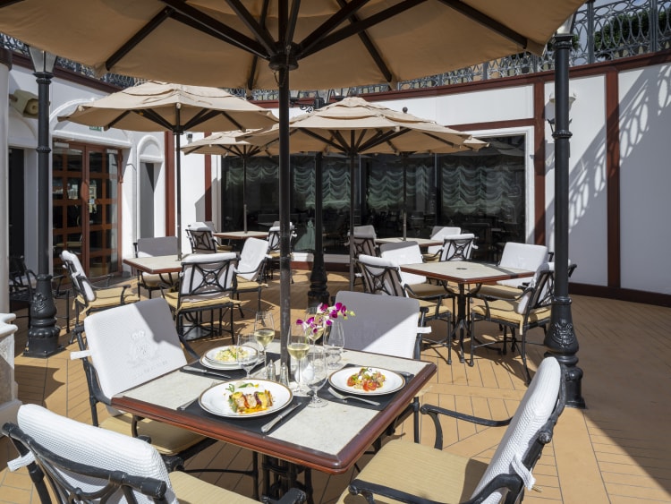 Queen Elizabeth's Grills courtyard, with al fresco dining in the sun, under parasols