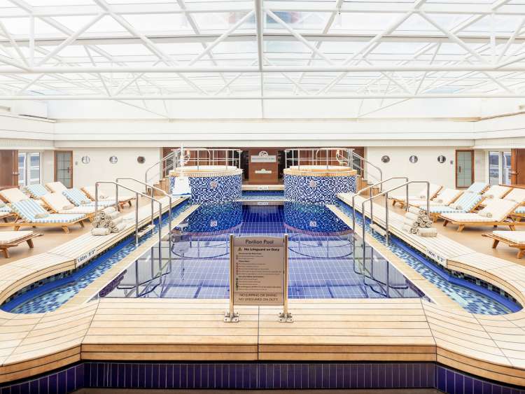 Pavilion pool area with sun loungers on board Cunard cruise ship Queen Mary 2