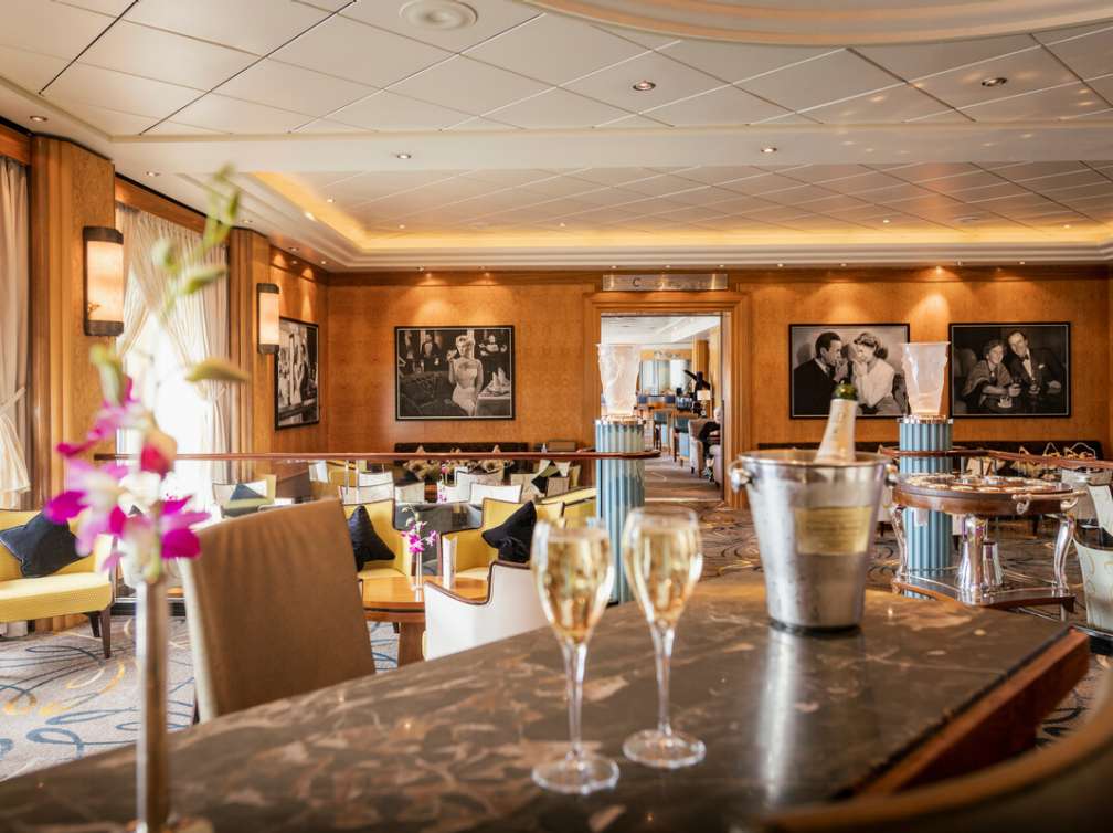 The Champagne Bar, on board Queen Mary 2, showing two glasses of champagne and a bottle in an ice bucket on the bar.