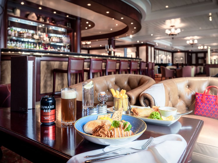 Traditional British pub food and Cunard Red beer on a table in the Golden Lion pub, on board Queen Mary 2