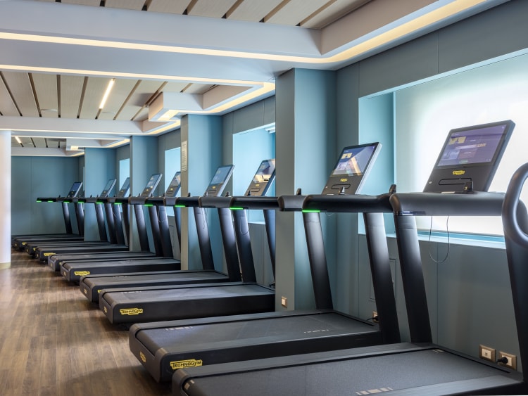 Treadmills in Queen Anne's fitness centre, lined up to face seaview windows