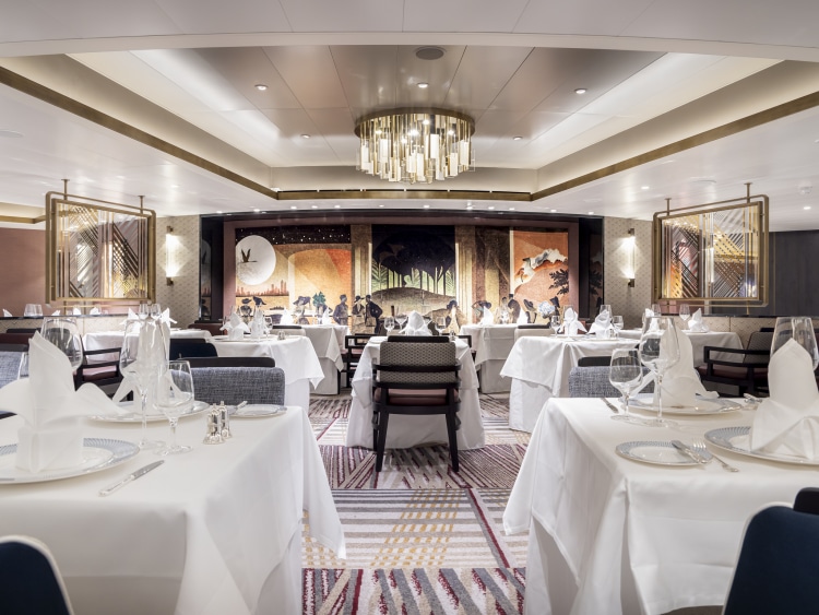 Wide shot of Queen Anne's Britannia Club restaurant, showing chandelier, wall murals, tables and chairs