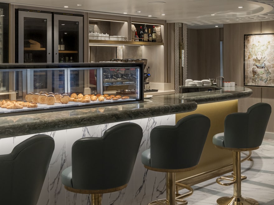 Queen Anne's Carinthia Lounge bar, with glass-fronted wine fridges and display of assorted pastries and cakes