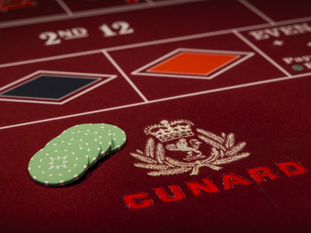 Card table with Cunard logo and gaming chips, in Queen Anne's casino