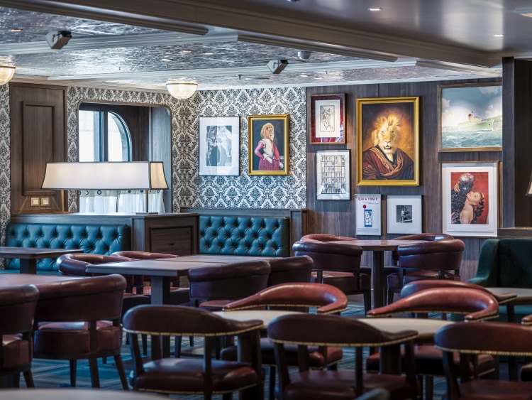 Queen Anne's Golden Lion pub, showing traditional British pub decor, sea views, tables and plush banquettes 