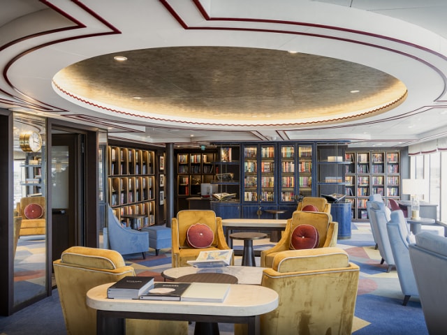 Library on Queen Anne, showing seating areas and floor-to-ceiling bookshelves full of books.